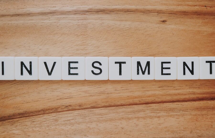 Scrabble tiles on a table that spells investment.