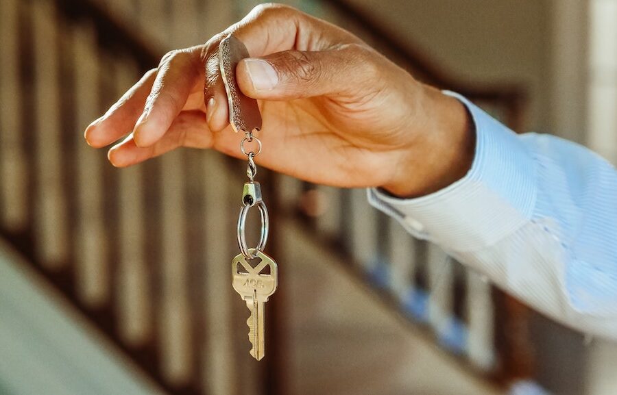 Black man's hand holding up a house key.