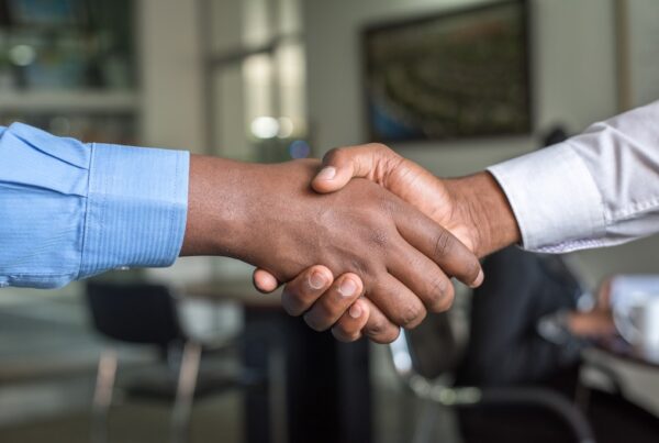 Two black businessmen shaking hands.