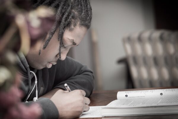 Black student doing homework at a desk.