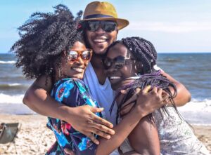 3 Black Friends hugging and enjoying time on the beach