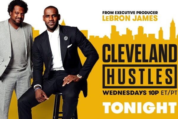 Two black men in a suit one sitting and one standing | Lebron James "Cleveland Hustles" Shows Racial Wealth Gap on Front Street