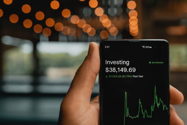 Investing on a smartphone held by a black man.
